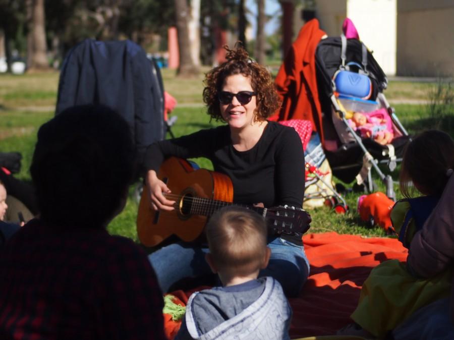 Nina con su guitarra en el grupo de juego en la naturaleza