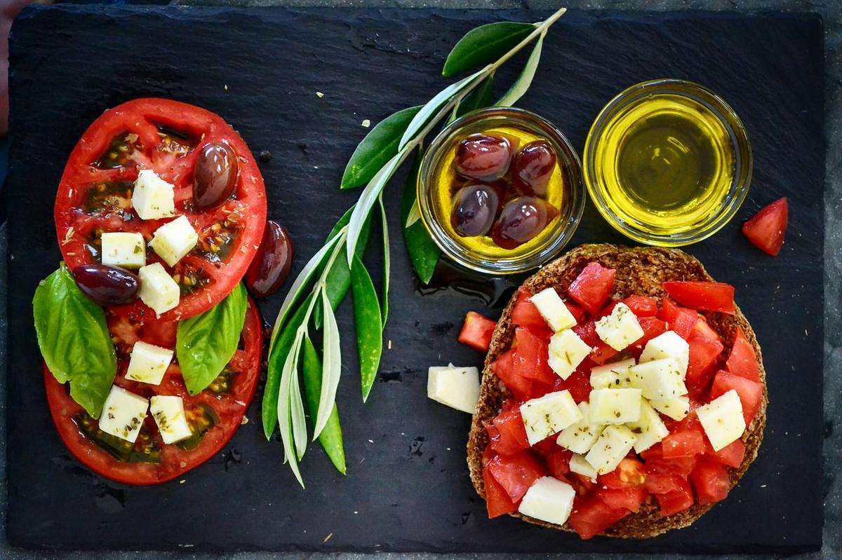 Dorada al horno con ingredientes de la dieta mediterránea como tomate, aceitunas y anchoas