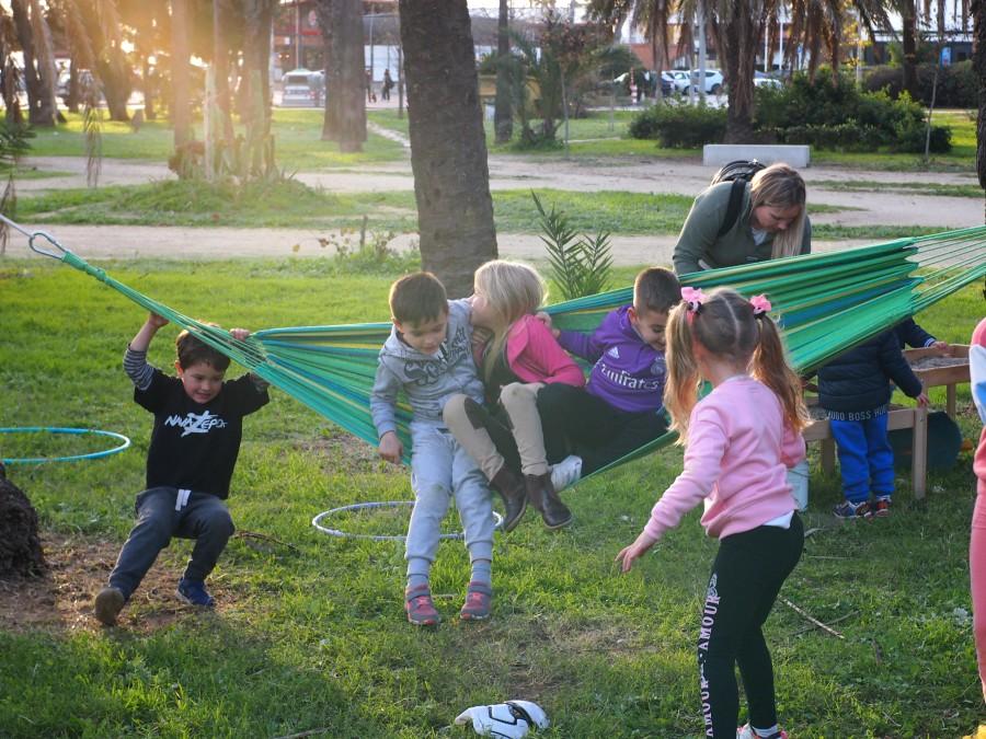 Niños y niñas jugando en una hamca en un parque 
