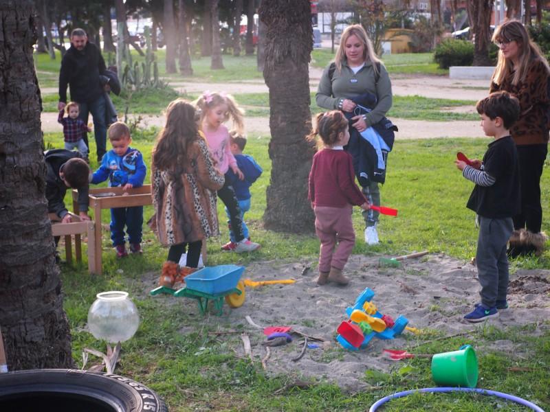 Niños y niñas jugando en el arenero. Familias acompañando que es una de las normas del grupo de juego