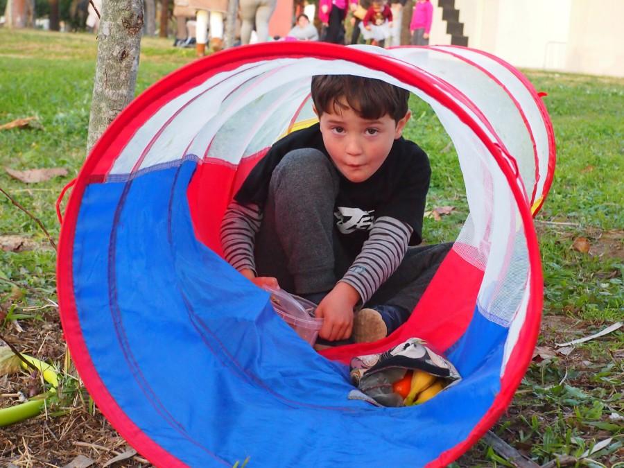 Niño merendando dentro del tubo de juego