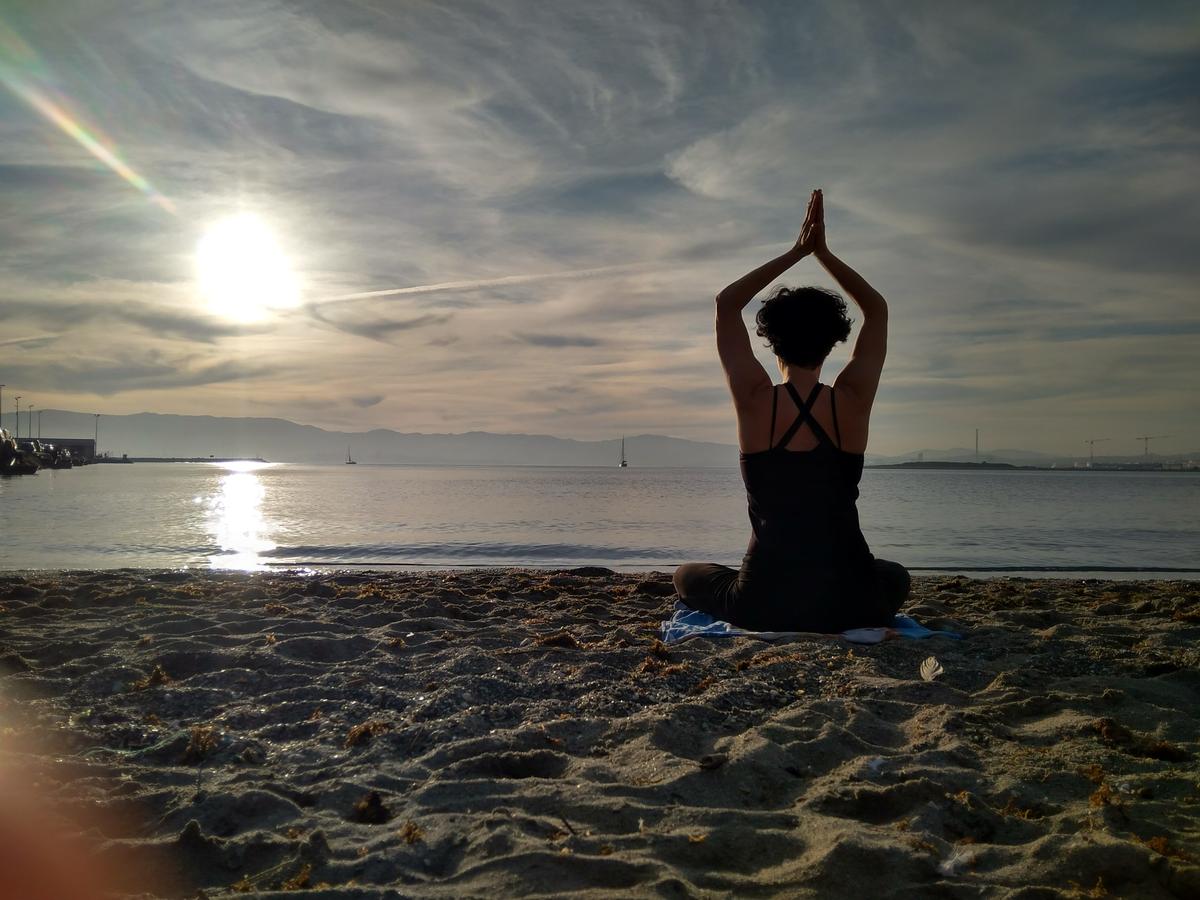 Foto haciendo yoga en la playa en un atardecer