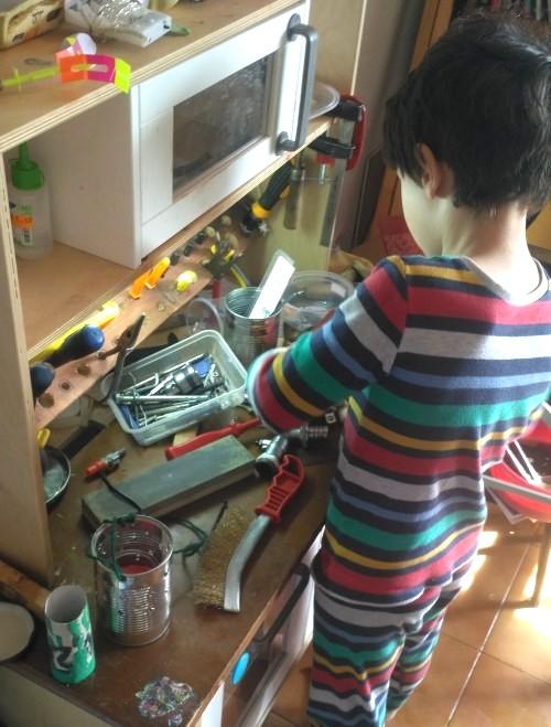 Un niño trabajando en un min taller convertido de cocina de ikea