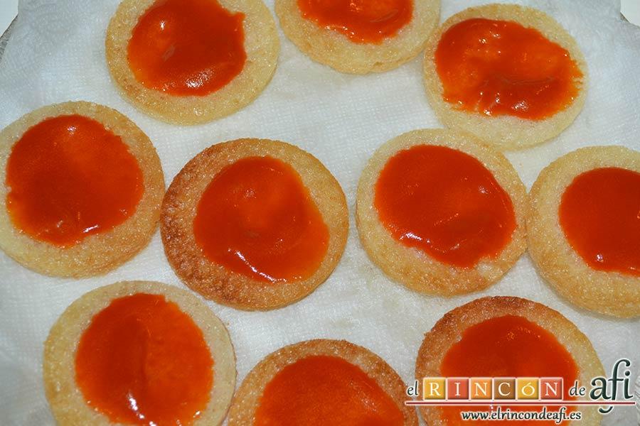 Mozzarella en carroza, untar los círculos de pan de molde fritos con salsa de tomate