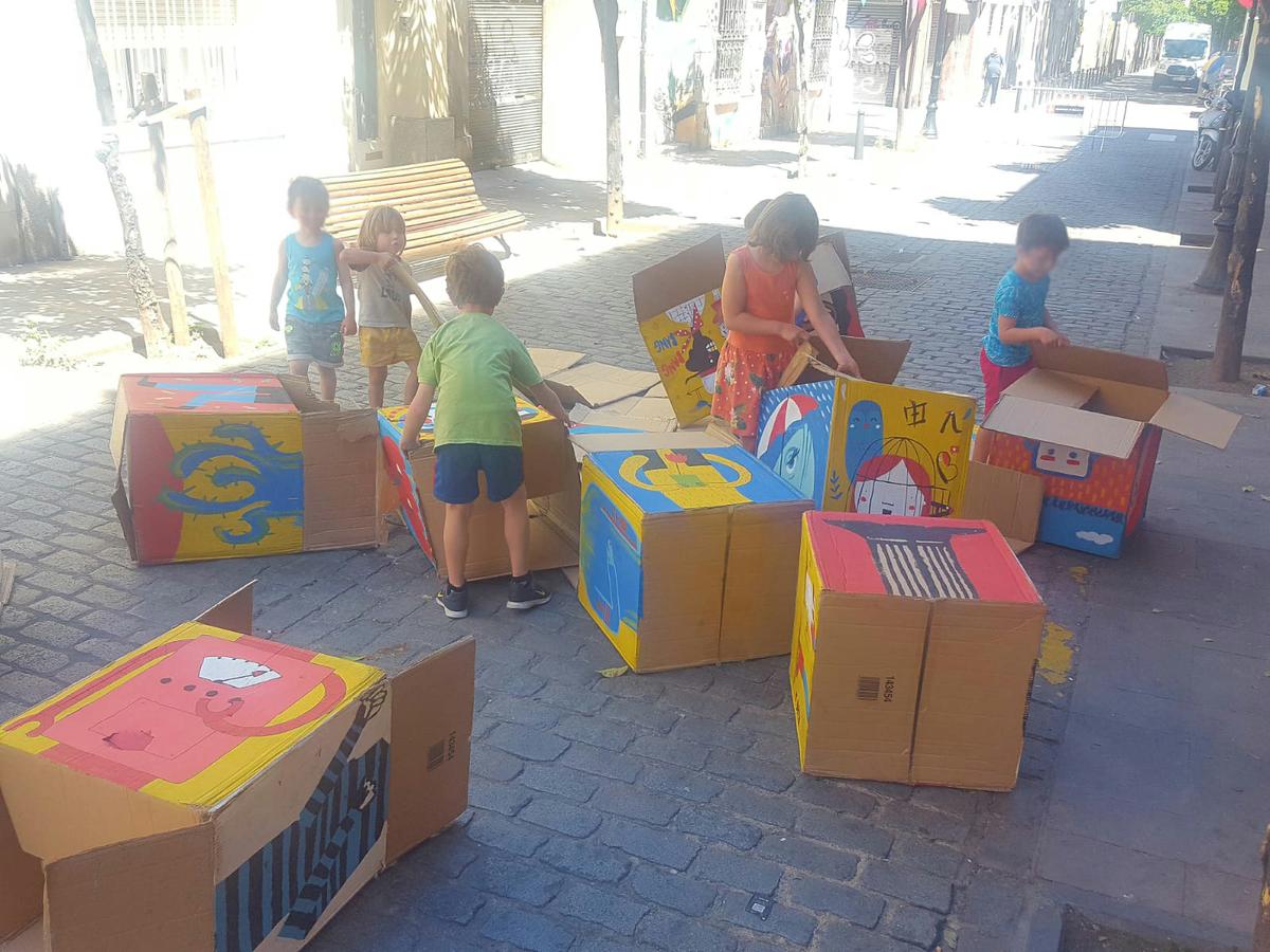 Puzle con cajas gigantes en para que los peques jueguen en una calle de barcelona