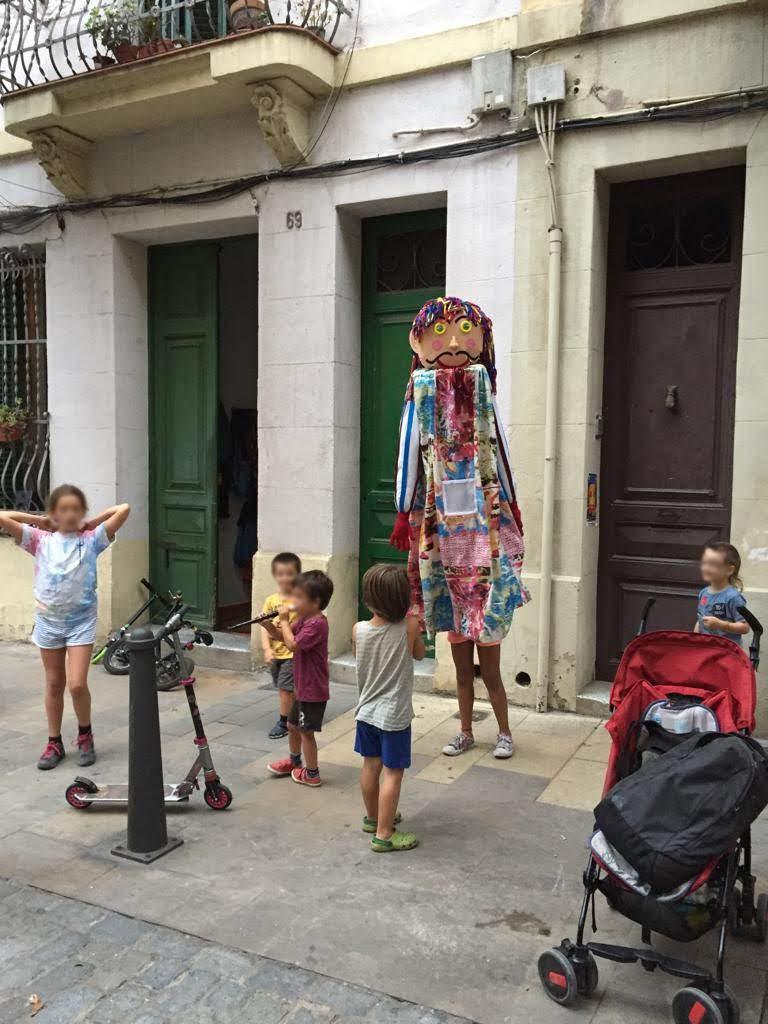 El Gegantó de Coroleu en acción con los niños en la fiesta de juego en una calle de Barcelola, territori infantil. 