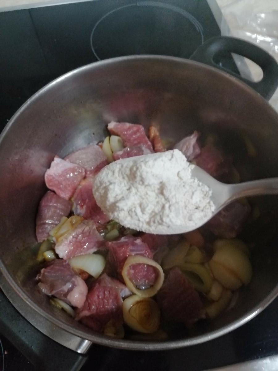añadiendo harina al sofrito de verdura y panceta
