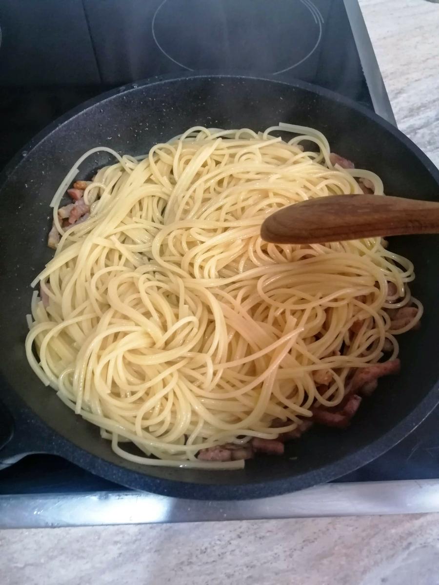mezclando espaguetis con la panceta