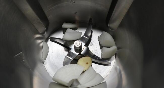 Echamos los ajos y la cebolla y los picamos con el robot de cocina