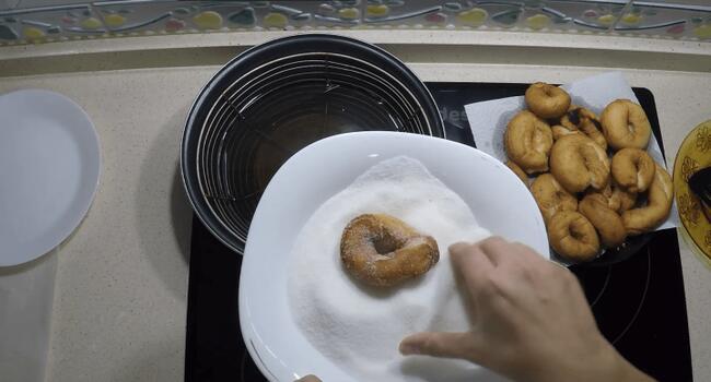 Untar las rosquillas con azúcar