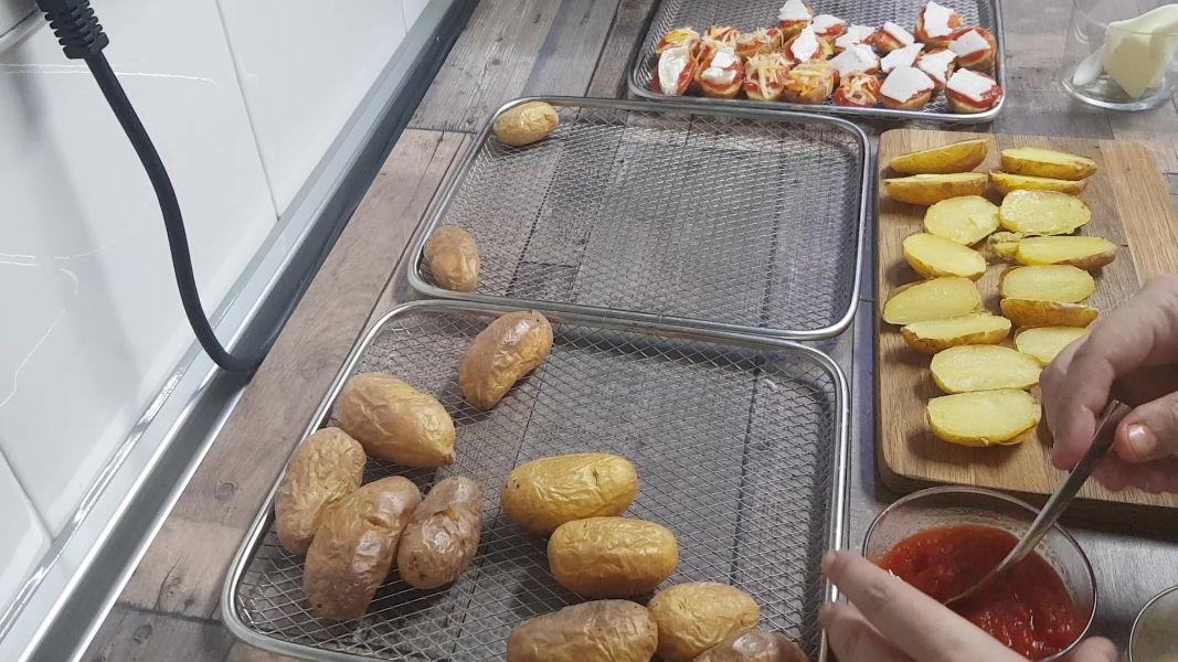 Patatas guarnición con tomate y queso en freidora de aire caliente