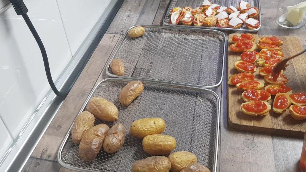 Patatas guarnición con tomate y queso en freidora de aire caliente