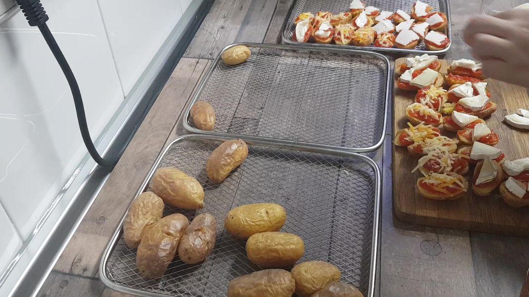 Patatas guarnición con tomate y queso en freidora de aire caliente