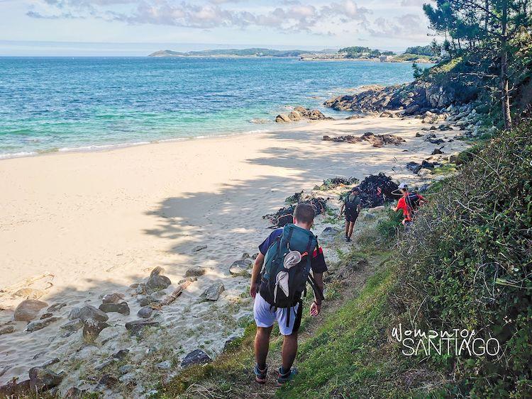 Peregrinos en una playa de Muxía