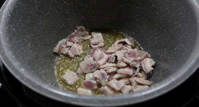 Echamos la panceta en la olla y rehogamos bien