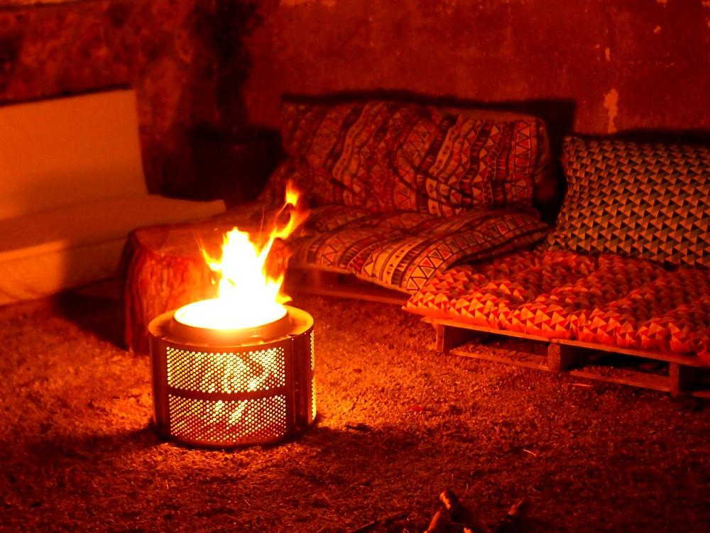 Tambor de lavadora con fogata u hoguera encendida dentro en el patio de mi hermana