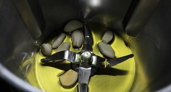 Echamos los ajos junto al aceite y troceamos bien