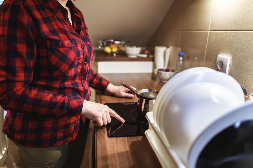 Mujer cocinando en placa de inducción
