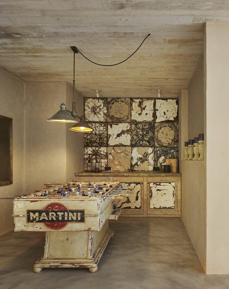 Un rincón aprovechado para el ocio: viejo futbolín en entorno de decoración rústica.