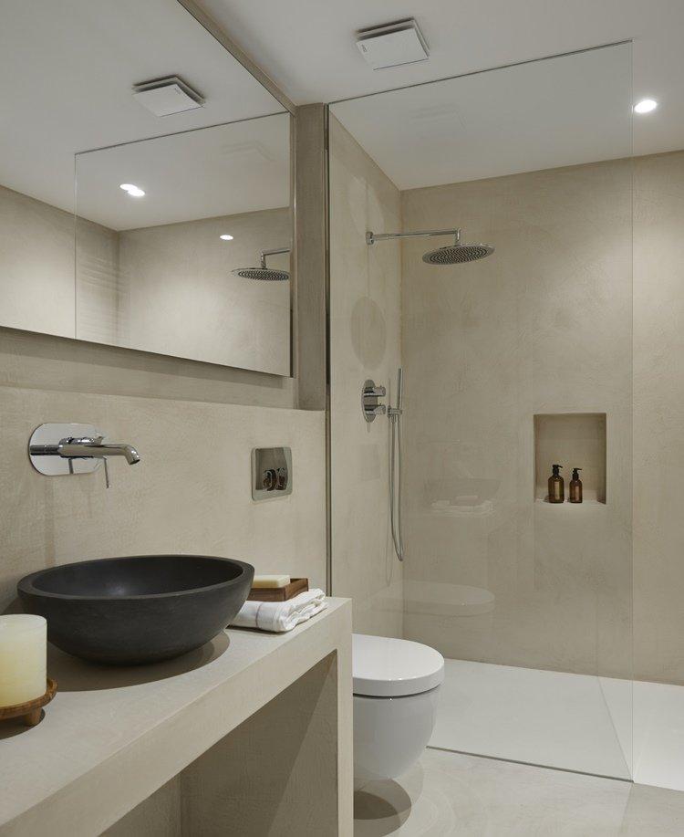 Un baño moderno con elementos rústicos como el lavabo.