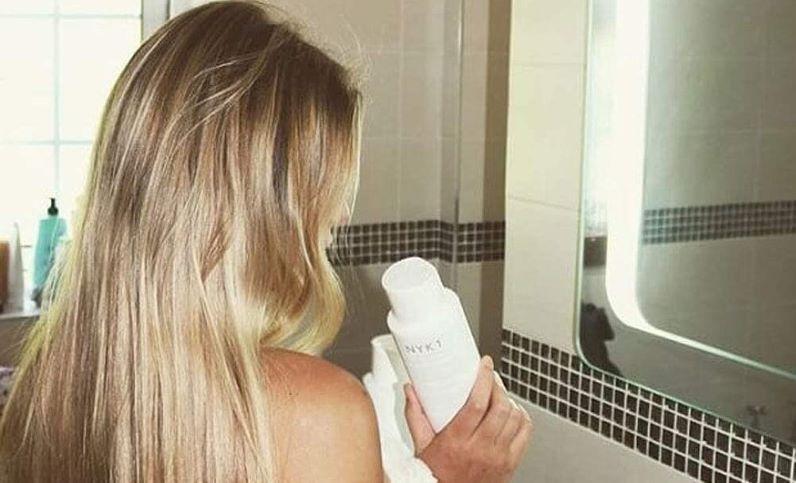 Chica con el pelo liso en el espejo