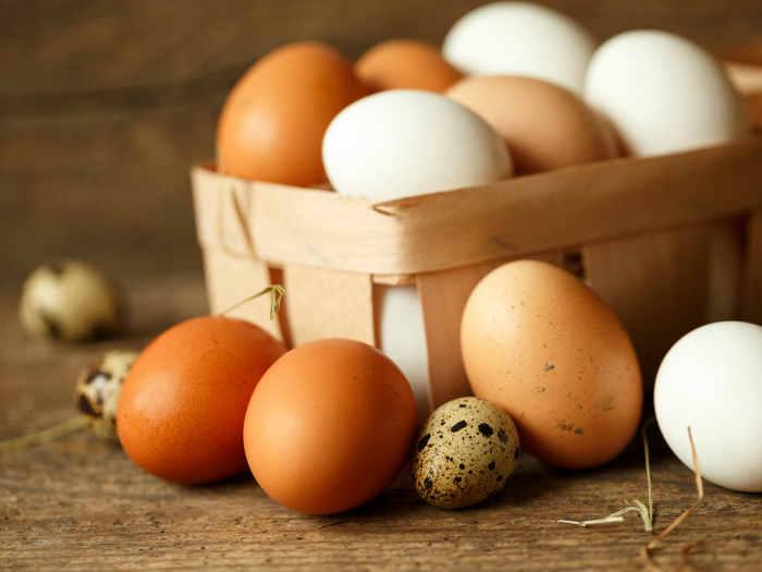 chicken and quail eggs on a wooden rustic background