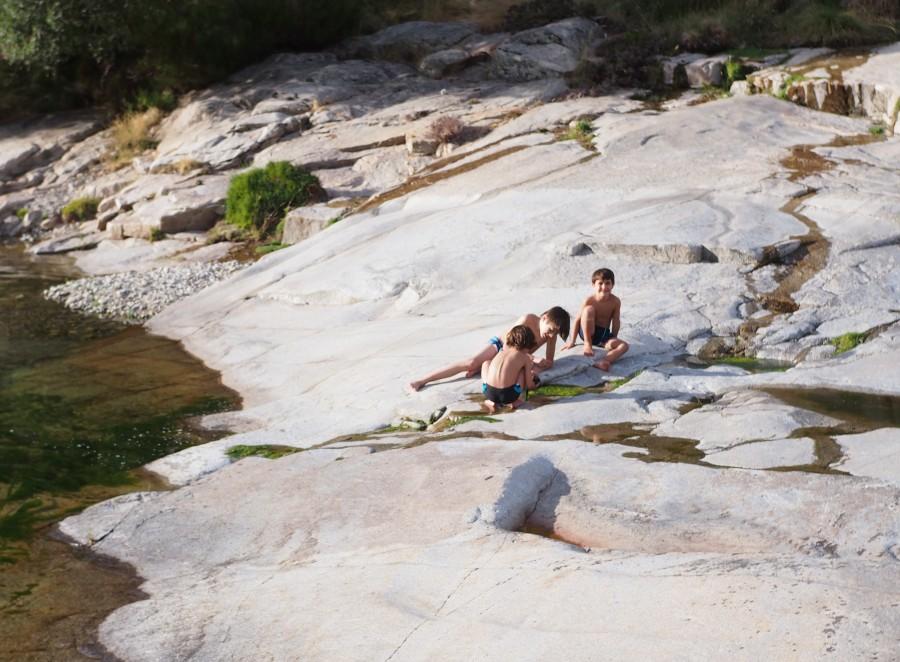 Niños jugando e investigando a la orilla de un rio 