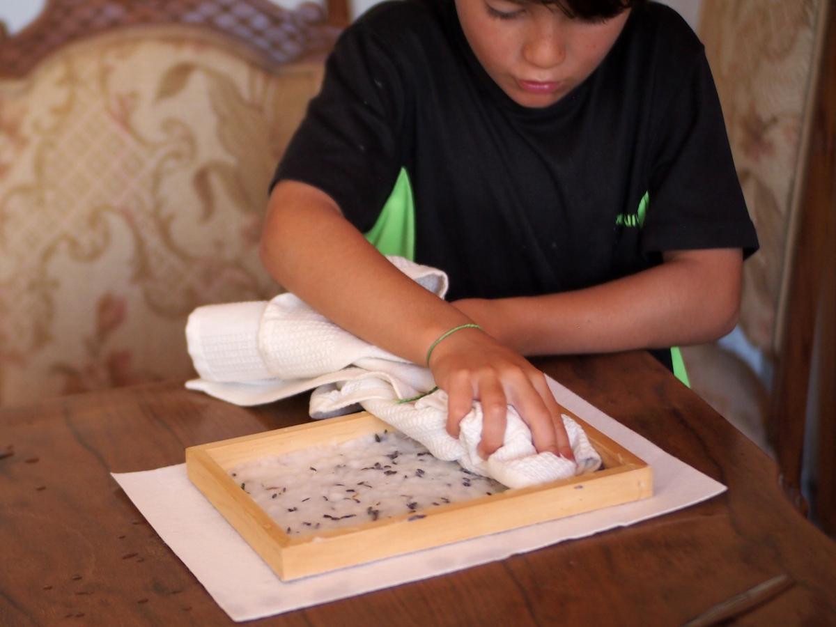 Niño secando el papelcasero con semillas