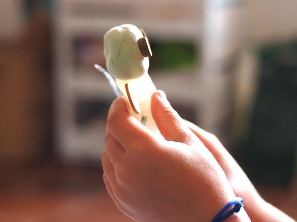 Manos de niño modelando una masa de modelar transparente para hcer un hada