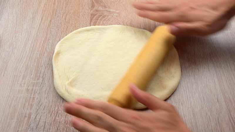 aplastar el pan plano indio con un rodillo