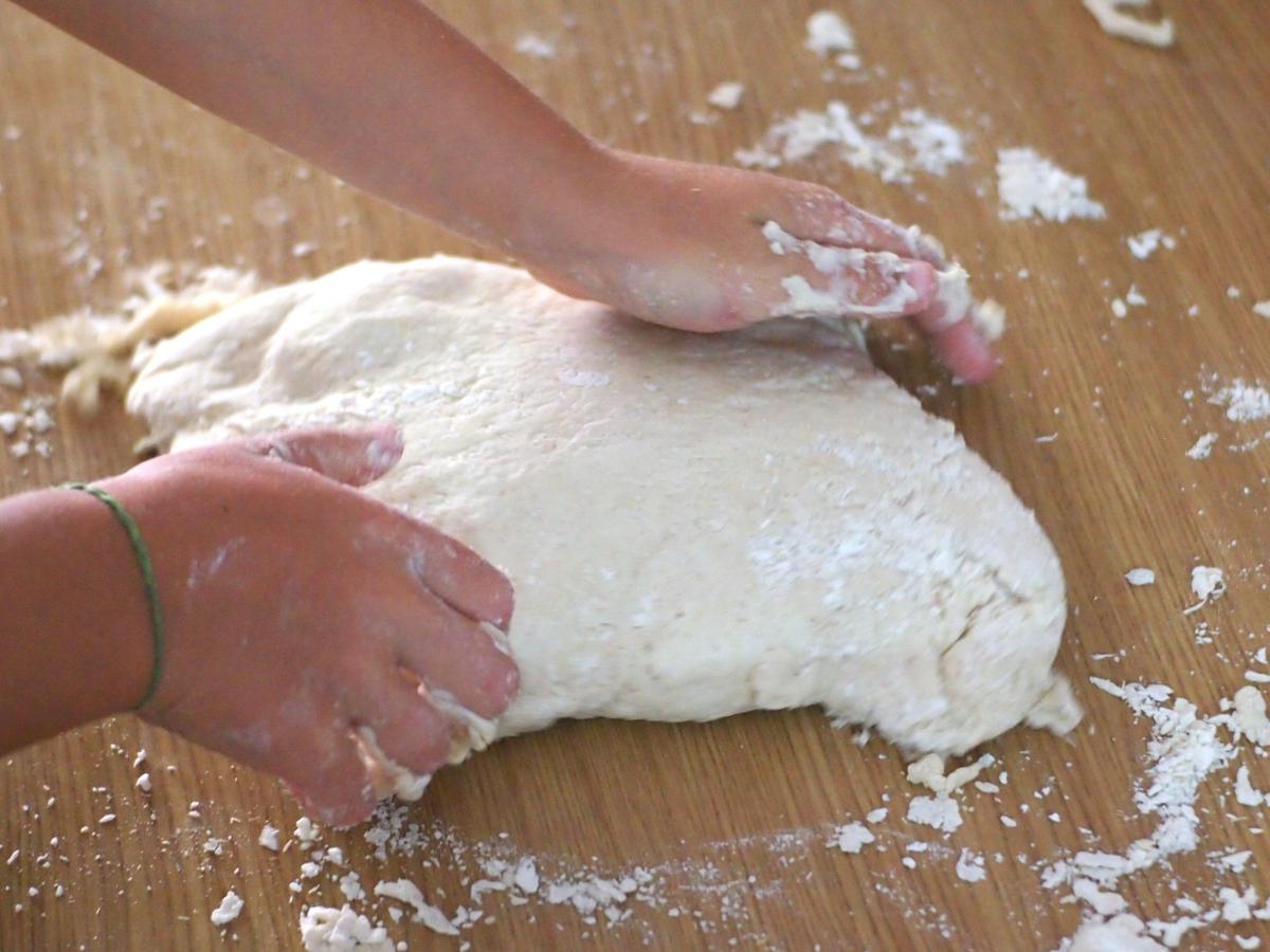 Manos de niño amasando pan