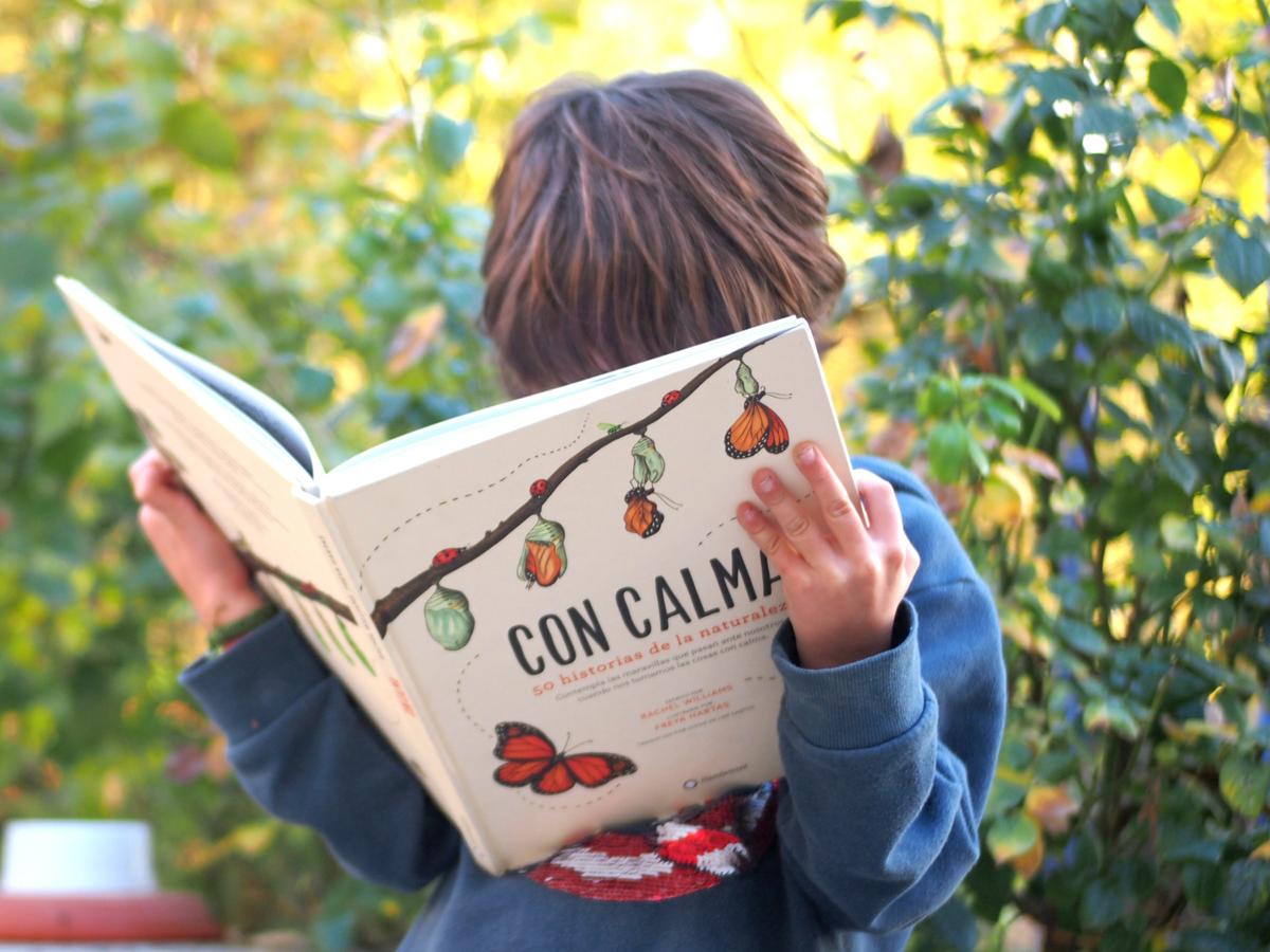 Niño leyendo el libro "Con calma, 50 historias de la naturaleza "