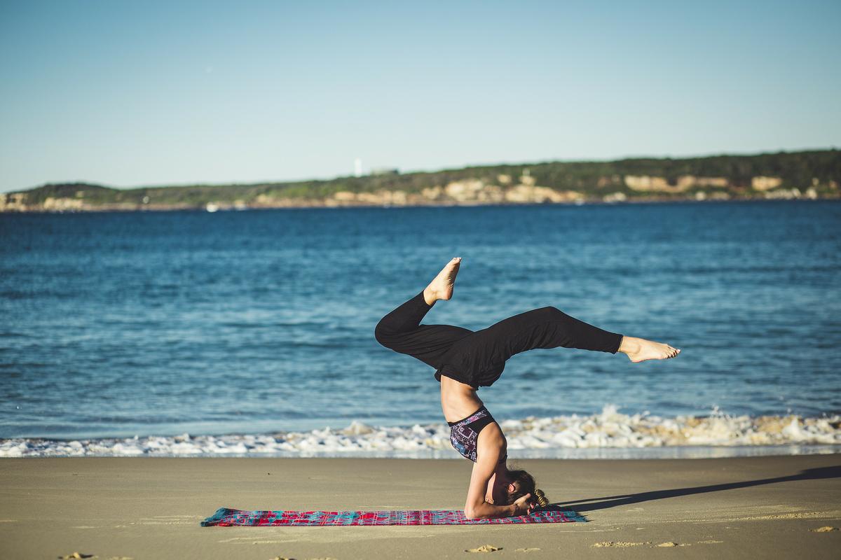 Mujer practica yoga en la playa: qué es yoga