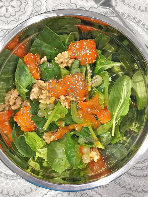 Ensalada de espinacas con caqui, nueces y uva - primer plano