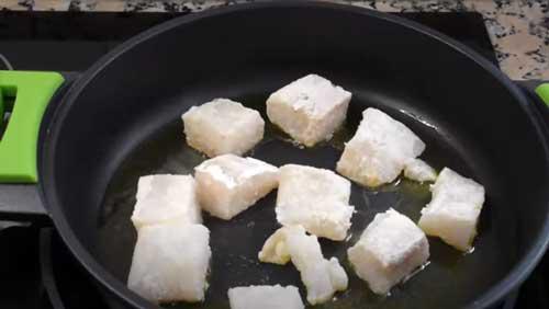 sofreir el pescado para las patatas con bacalao