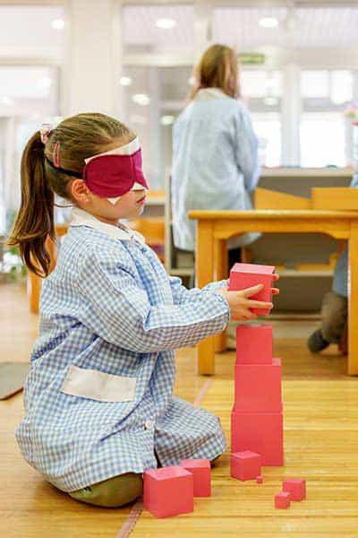 niña con torre rosa de Montessori