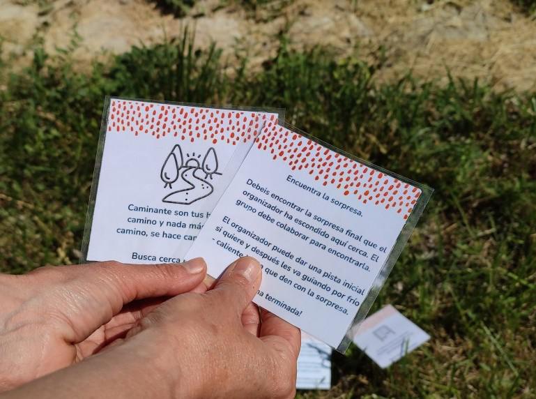 Foto de la gincana de la naturaleza donde se ven unas manos sujetando las tarjetas