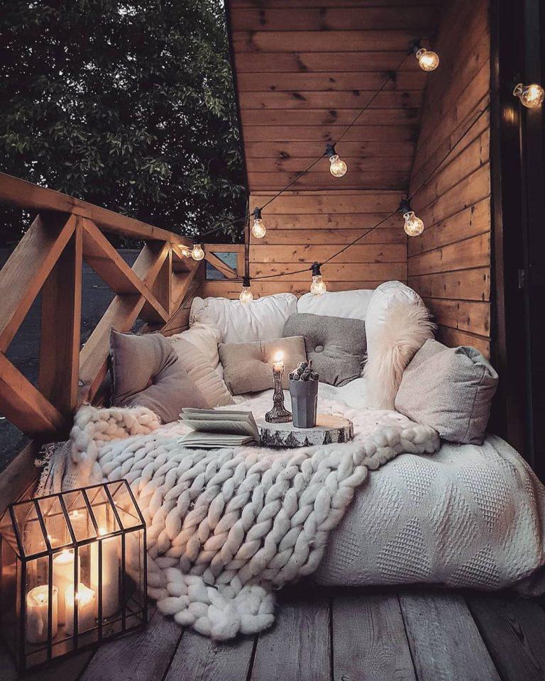 Decoración cálida de balcón con guirnaldas solares de bulbos.