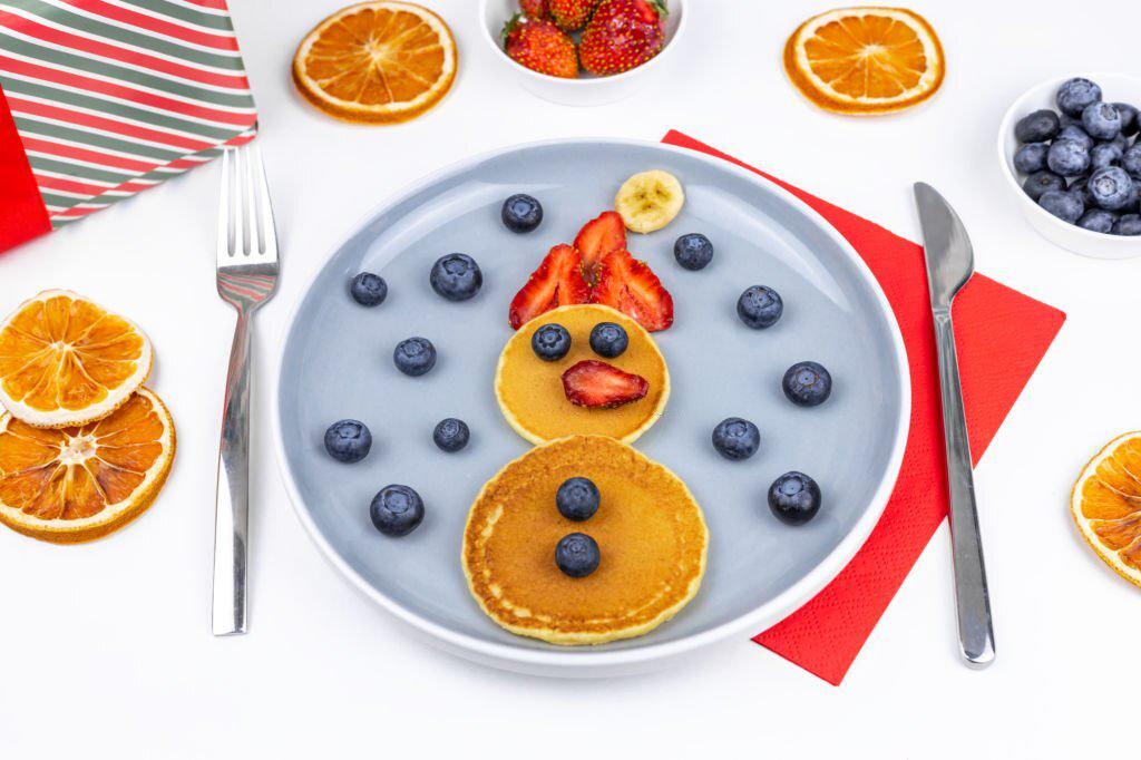 Muñeco de nieve con crepes, fresas, plátanos y arándanos