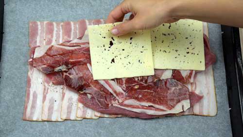colocar lonchas de jamon y queso sobre la carne al horno de solomillo relleno