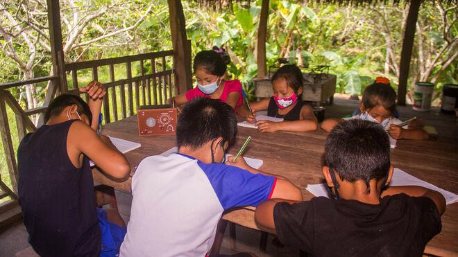 niños estudiando con la radio