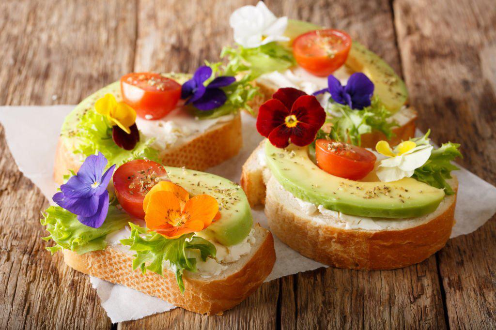 Canapés de aguacate, queso crema y flores comestibles