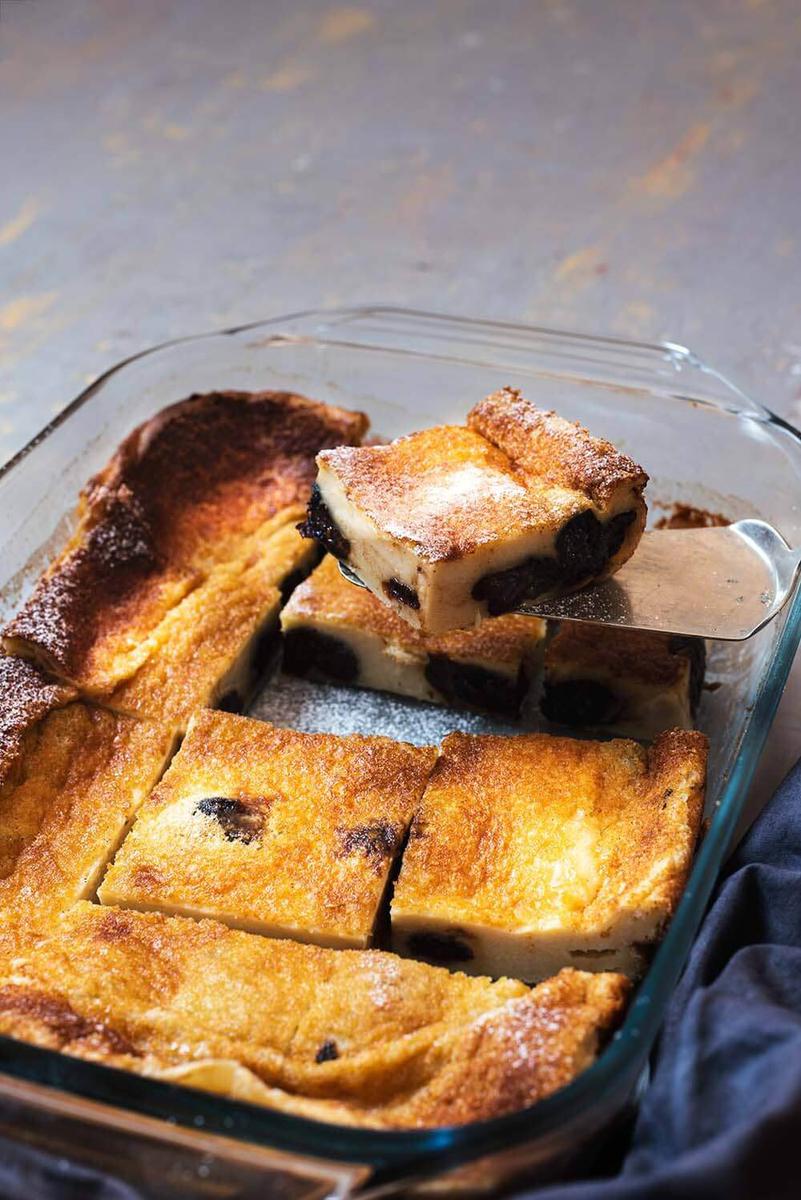 En la mesa gris hay un recipiente donde está el postre Far Bretón cortado.