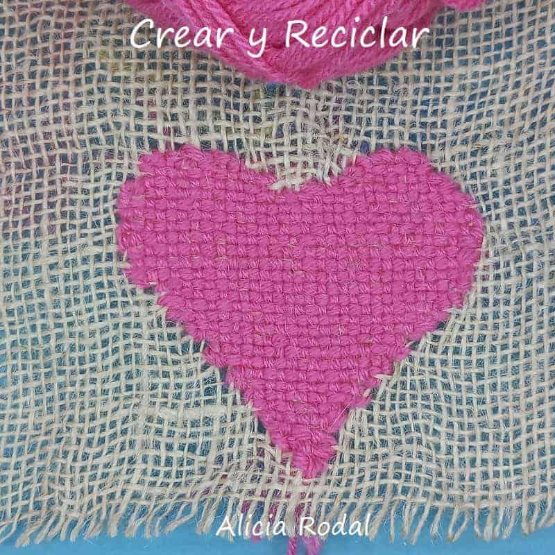 En este tutorial vamos a aprender a coser unas figuras en forma de corazones, con hilos de lana, sobre la tela de saco o yute. Para eso vamos a hacer puntos básicos en la tela de saco. Esta es la idea Nivel principiante Parte 2