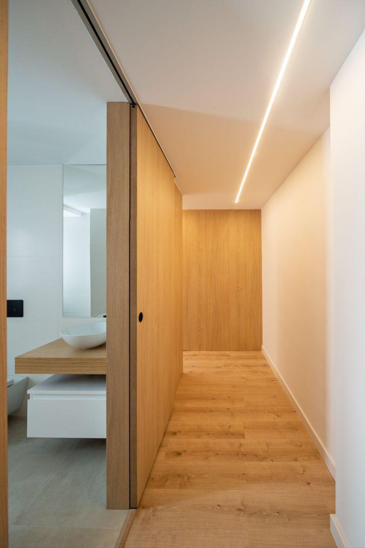 Pasillo de entrada de madera y baño moderno