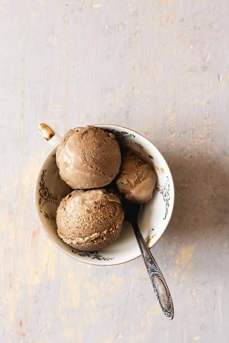 Un una taza hay tres bolas de helado de café junto con una cuchara.