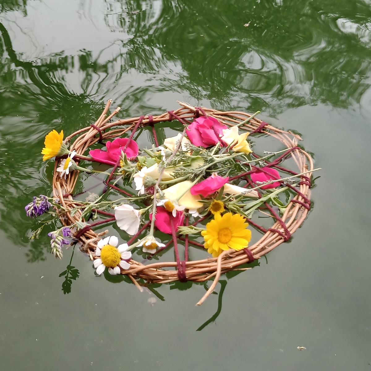 Barquito oferente de flores en el agua