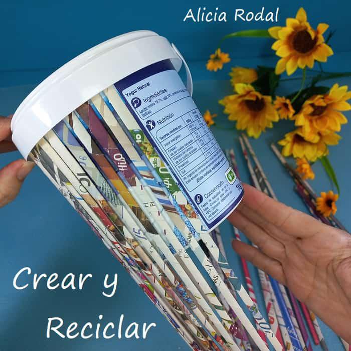 En este tutorial veremos cómo decorar un envase en forma de pote o cesta plástica, con papel periódico o revistas viejas para conseguir un efecto como de madera. Es la decoración de un recipiente, tarro o tarrina de helado o yogur, haciendo la imitación de tablas o palos de madera. DIY