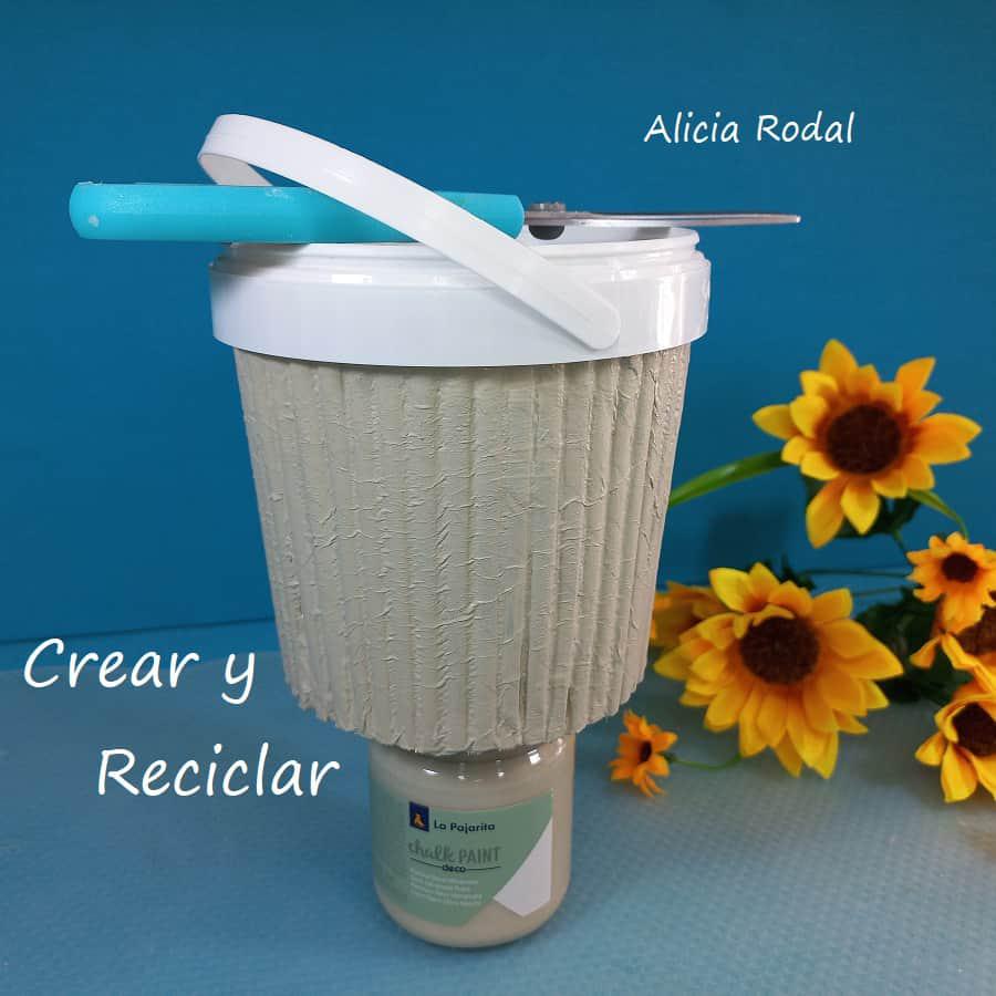 En este tutorial veremos cómo decorar un envase en forma de pote o cesta plástica, con papel periódico o revistas viejas para conseguir un efecto como de madera. Es la decoración de un recipiente, tarro o tarrina de helado o yogur, haciendo la imitación de tablas o palos de madera. DIY