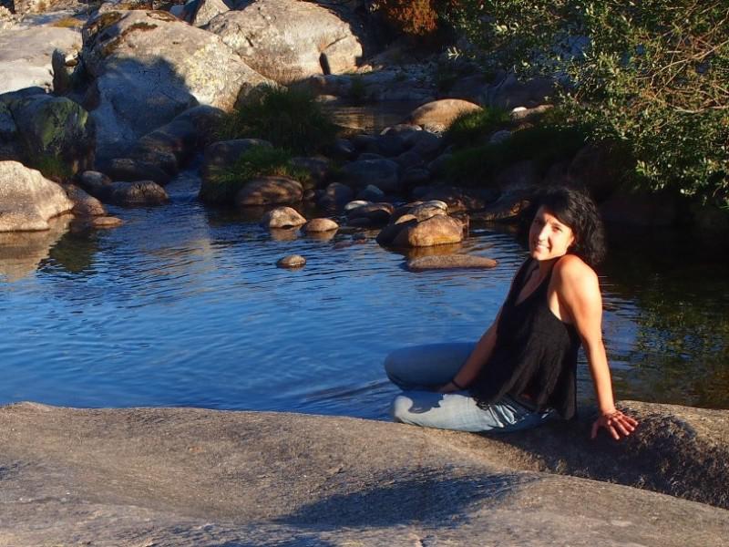 Foto de Llanos Nuñez en una piedra de granito de un río sonriendo